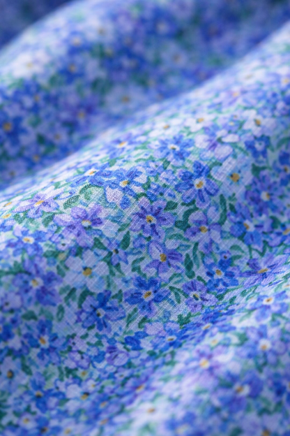 Détail tissu robe d’été bleue : motif fleuri sur fond bleu clair