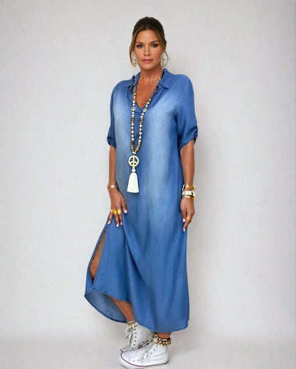Robe longue en jean bleu, encolure en V, manches courtes bouffantes, fente latérale.