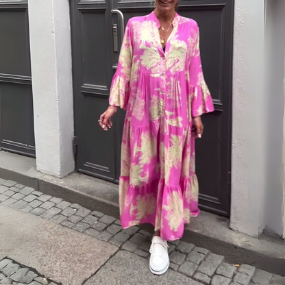 Robe longue rose à imprimé doré, col chemise et volants en bas.