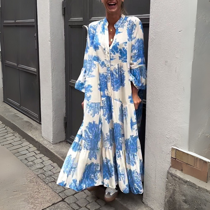 Robe longue blanche à imprimé bleu, boutonnage et jupe évasée à volants.