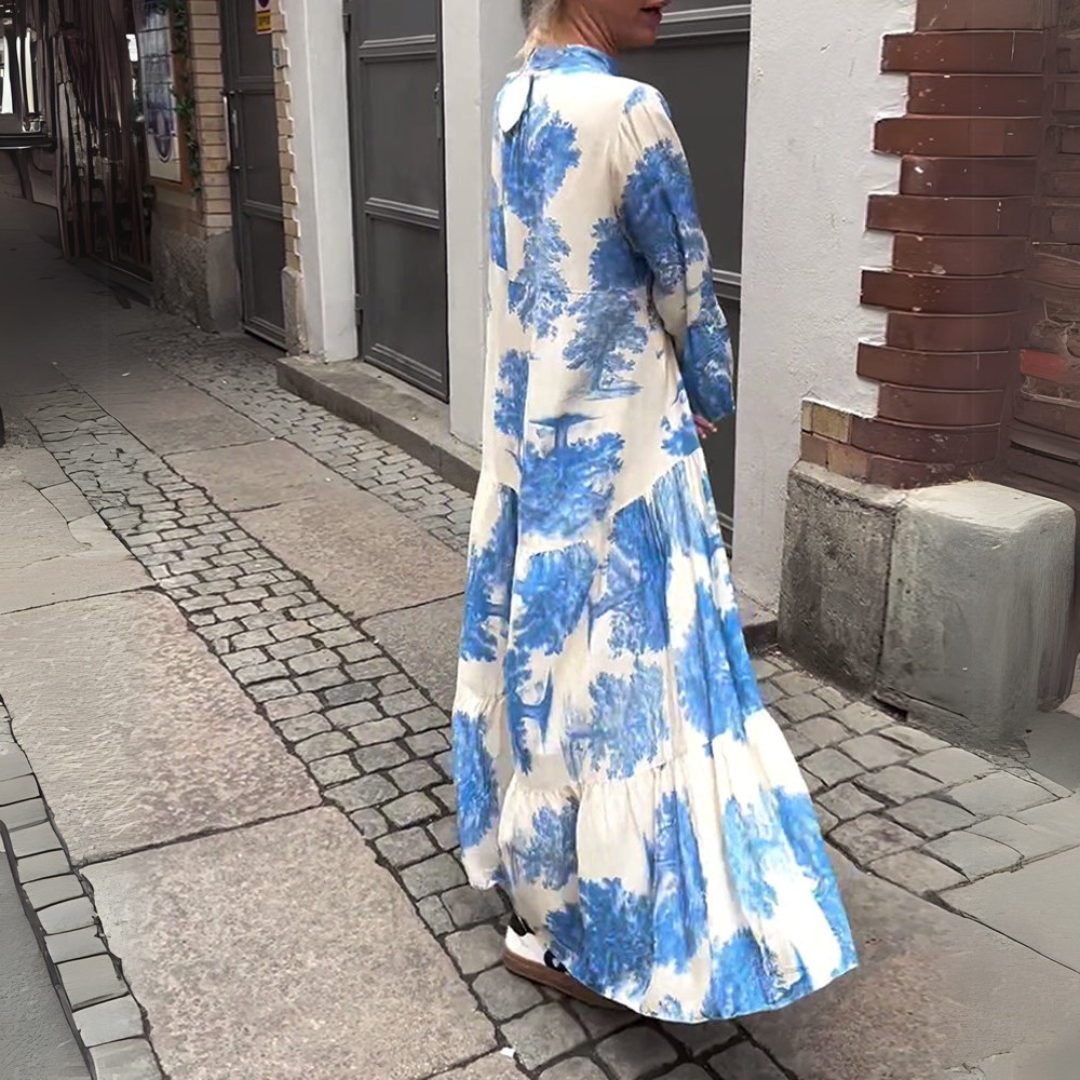 Robe longue blanche à imprimé bleu, manches longues évasées et col V.
