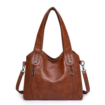 Sac à bandoulière en cuir marron, anses avec attaches métalliques et fermeture zippée