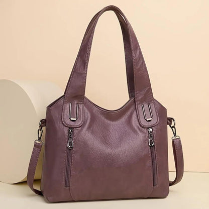 Sac à bandoulière en cuir violet, fermetures zippées et bandoulière réglable