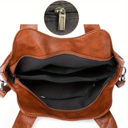 Sac à bandoulière marron ouvert : intérieur noir et poche zippée visibles