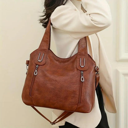 Sac à bandoulière en cuir marron sur l’épaule, bandoulière réglable