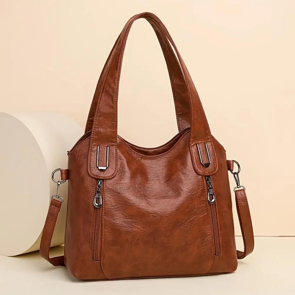 Sac à bandoulière en cuir marron, forme trapèze et bandoulière amovible