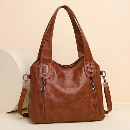 Sac à bandoulière en cuir marron, forme trapèze et bandoulière amovible