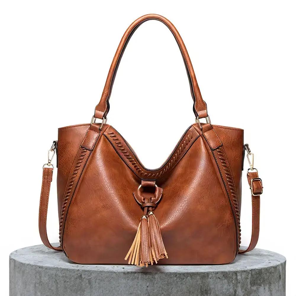 Sac à bandoulière en cuir marron, anses rigides, poche zippée et gland