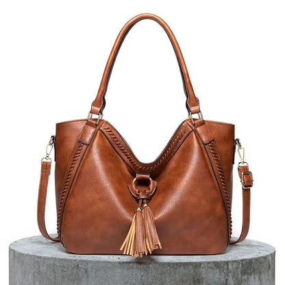 Sac à bandoulière en cuir marron, anses rigides, poche zippée et gland