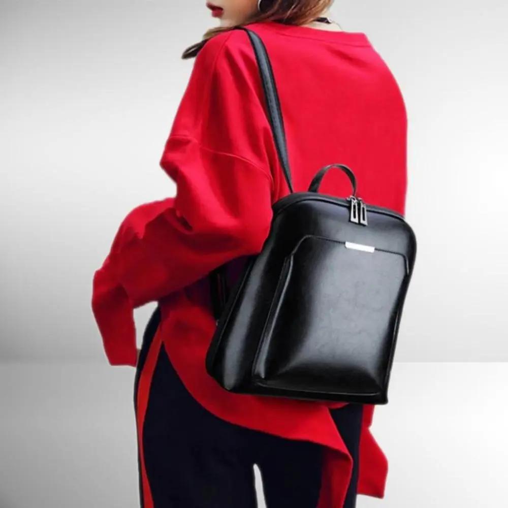 Sac à dos en cuir noir à double zip, porté avec deux bretelles
