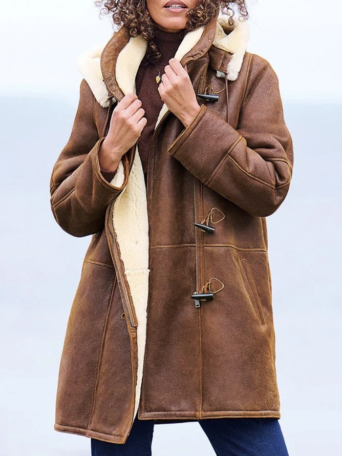 Manteau chaud marron avec capuche et doublure sherpa, attaches métalliques décoratives.