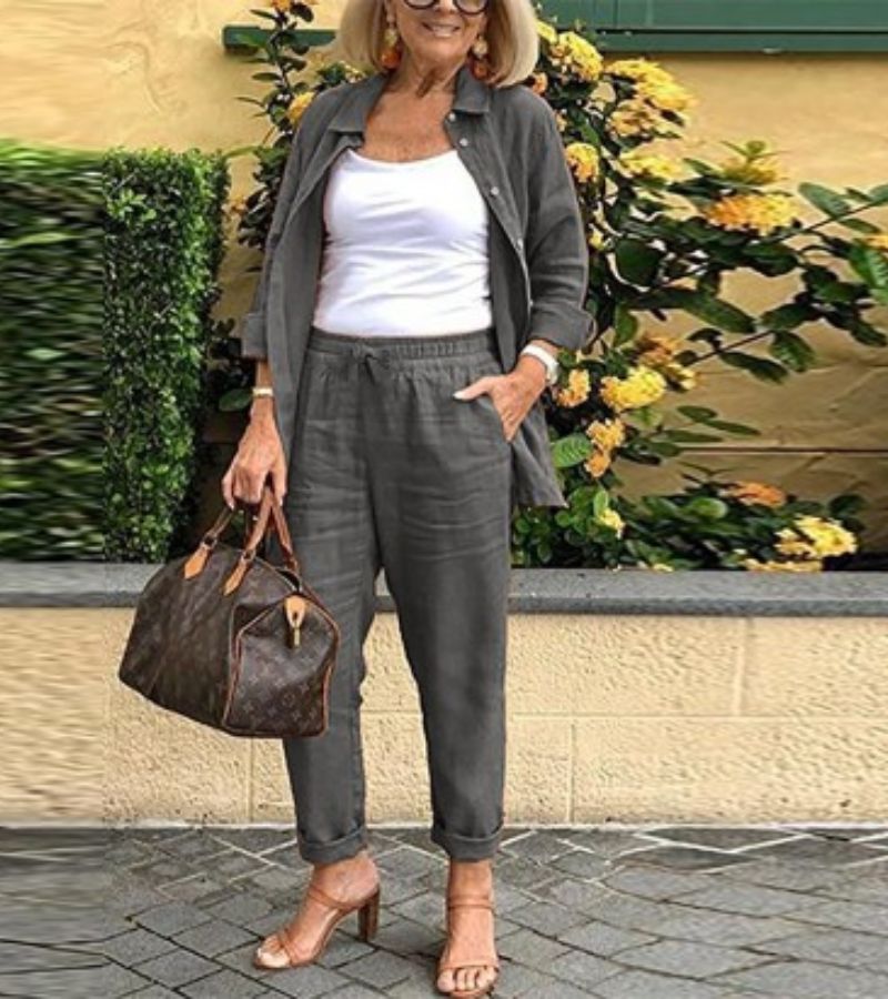 Ensemble chemise et pantalon en lin-coton gris foncé, coupe ample, col simple et boutons.