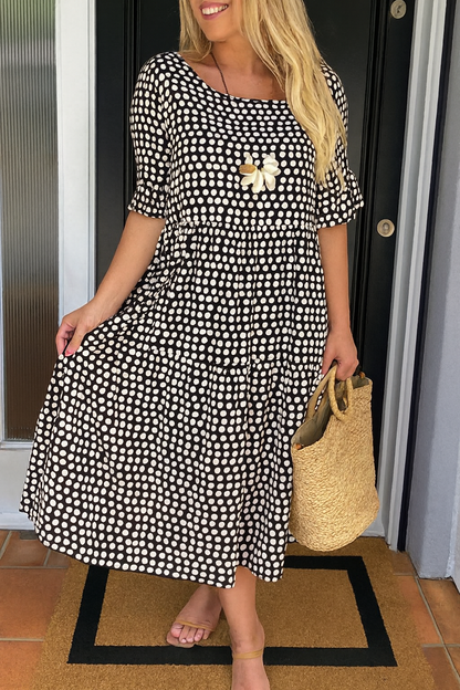Robe midi fluide noire à pois blancs, manches courtes, fleur brodée au buste, coupe évasée.