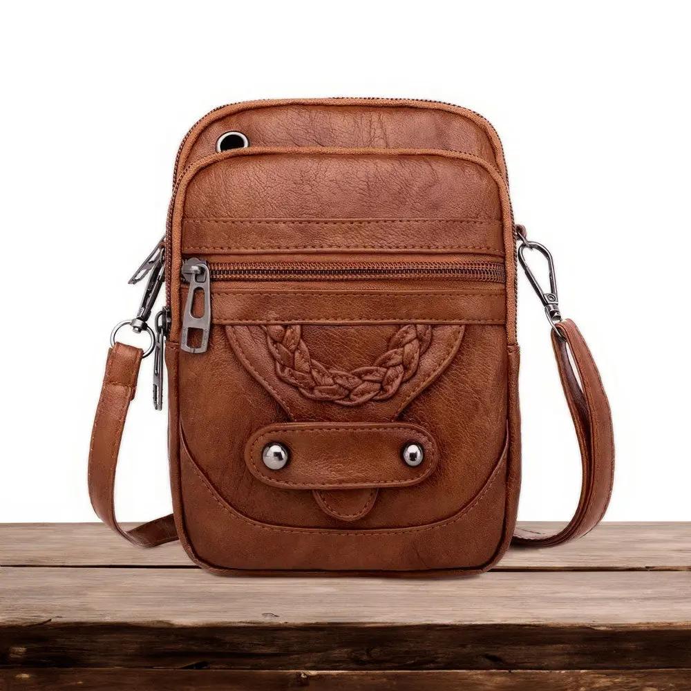Sac à bandoulière en cuir marron, poche frontale et bride avec anneaux métalliques