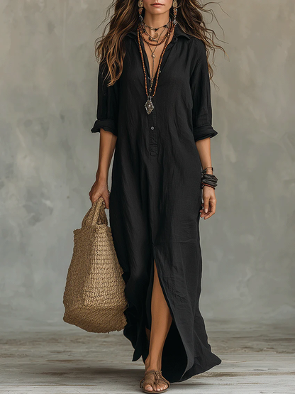 Robe longue noire boutonnée, col en V, fente avant, manches au coude, tenue ample.