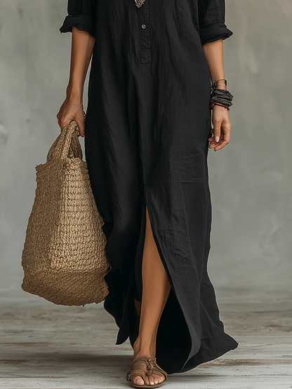 Robe longue noire boutonnée, ourlet au sol, fente avant, manches trois-quarts, coupe fluide.