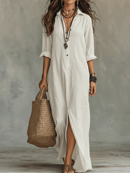 Robe longue boutonnée blanche, col en V, manches trois-quarts, fente avant, tissu fluide.