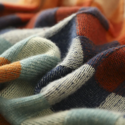 Détail du tricot du pull en cachemire, carreaux bleu marine, orange et vert.