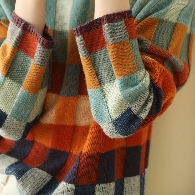Pull en cachemire col roulé, manches volumineuses, carreaux orange et bleu.