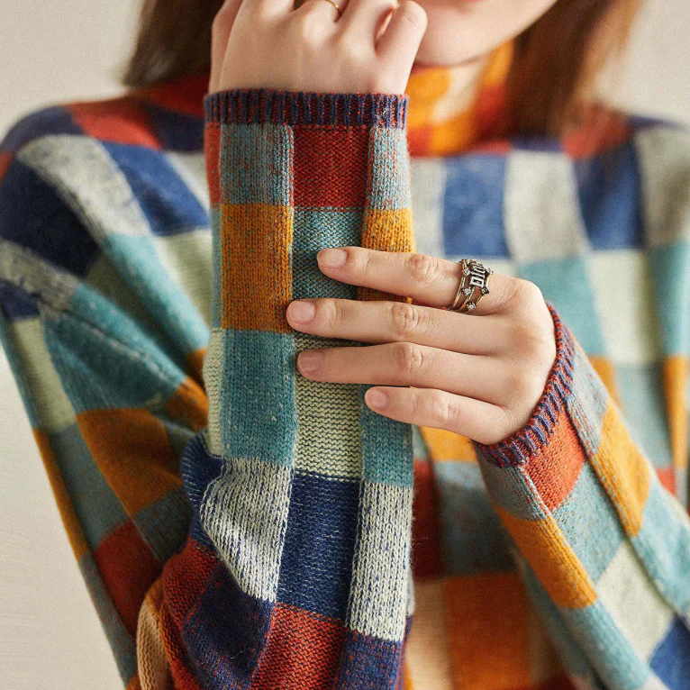 Pull en cachemire à col roulé, carreaux orange, vert, bleu et beige ; vue rapprochée.