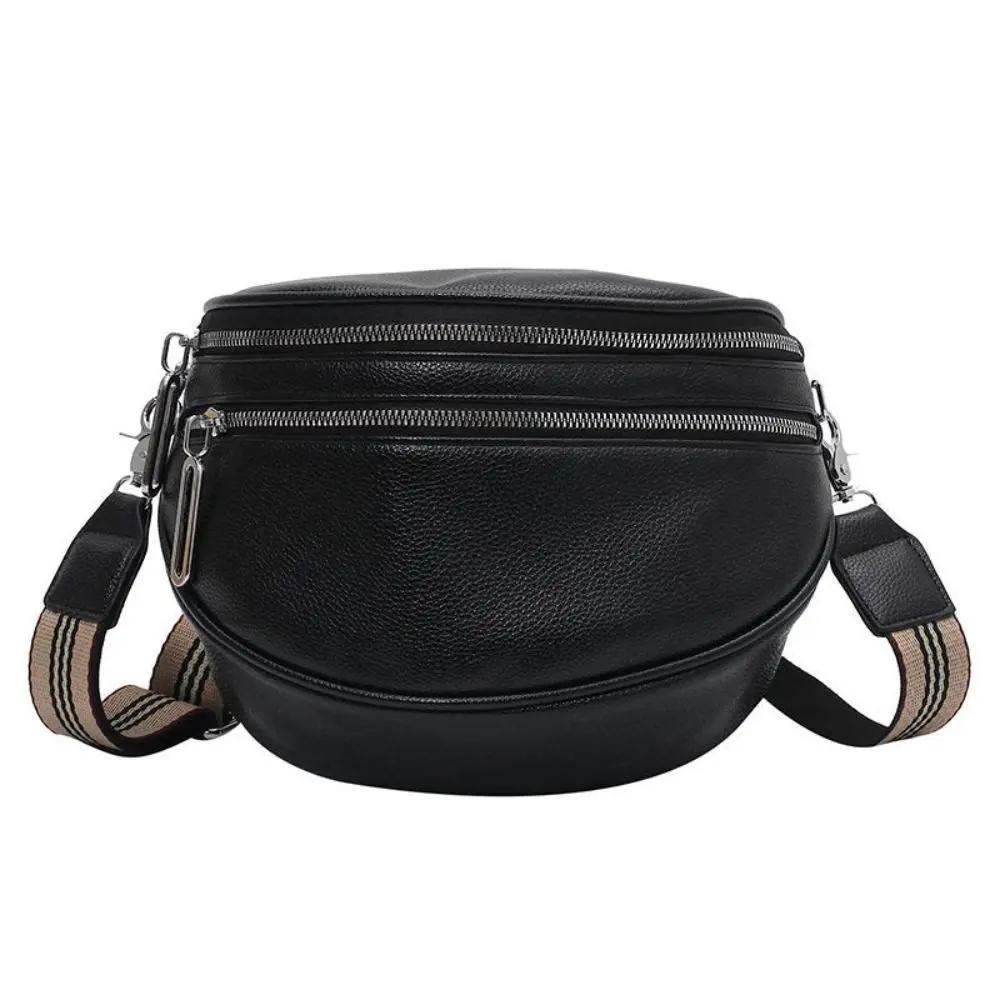 Sac à bandoulière Mira noir, arrondi, double fermeture éclair et bandoulière rayée.