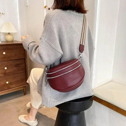 Sac à bandoulière Mira bordeaux, porté sur l’épaule, sangle rayée réglable.