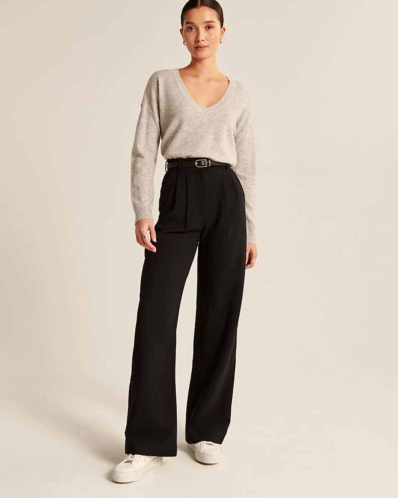 Pantalon noir taille haute à pinces, jambes larges, fermeture boutonnée et braguette.