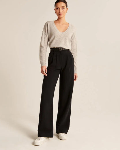 Pantalon noir taille haute à pinces, jambes larges, fermeture boutonnée et braguette.
