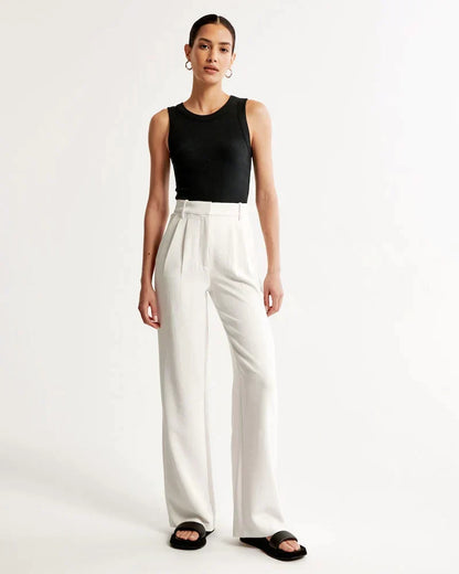 Pantalon blanc taille haute à jambes larges, fermeture dissimulée et passants de ceinture.