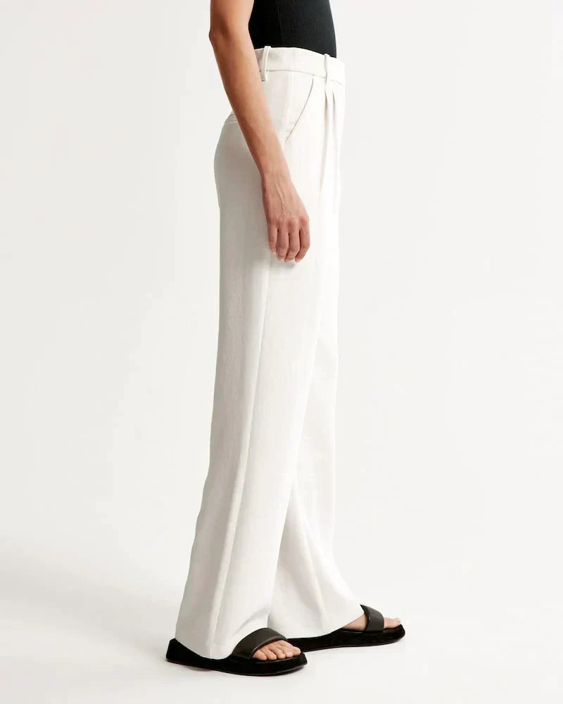 Pantalon blanc taille haute, coupe ample jambes larges, passants de ceinture.