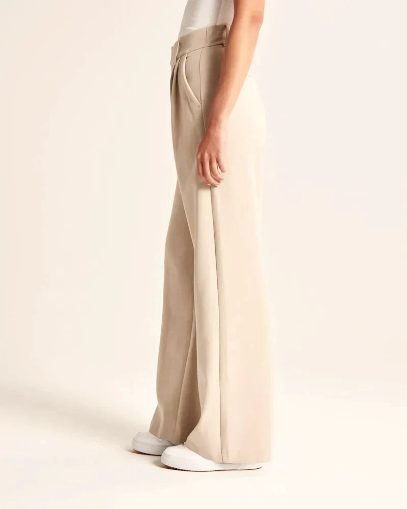 Pantalon fluide beige à jambe droite, taille ceinturée, poches latérales visibles
