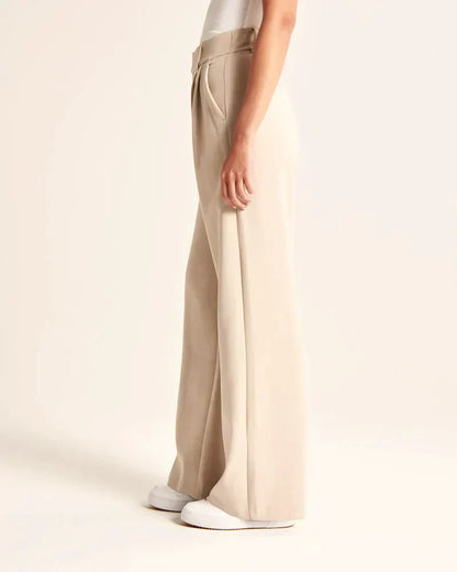 Pantalon fluide beige à jambe droite, taille ceinturée, poches latérales visibles