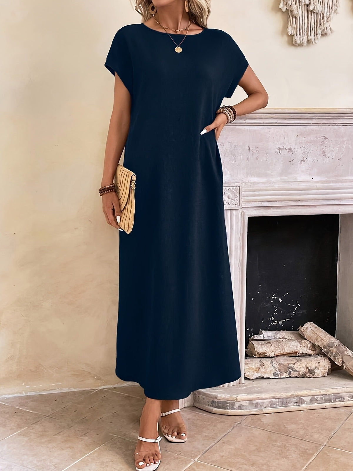 Robe longue sombre à manches courtes et encolure ronde, coupe droite.