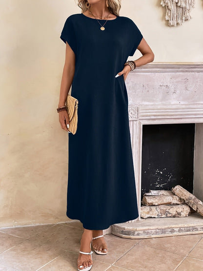 Robe longue sombre à manches courtes et encolure ronde, coupe droite.