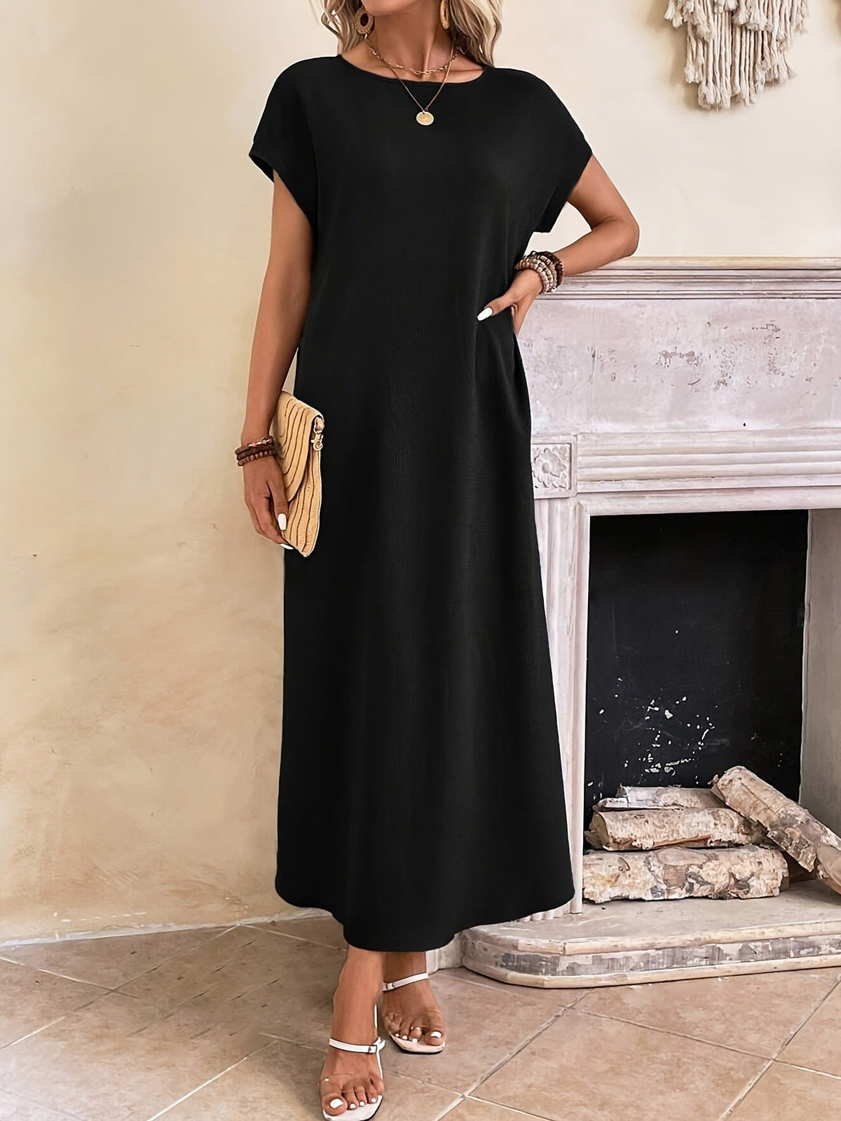 Robe longue sombre à manches courtes et encolure ronde, coupe droite.