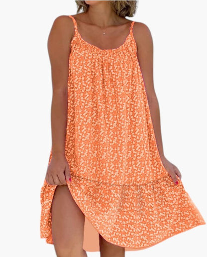 Robe légère orange à petites fleurs, bretelles fines, encolure arrondie, ourlet asymétrique.