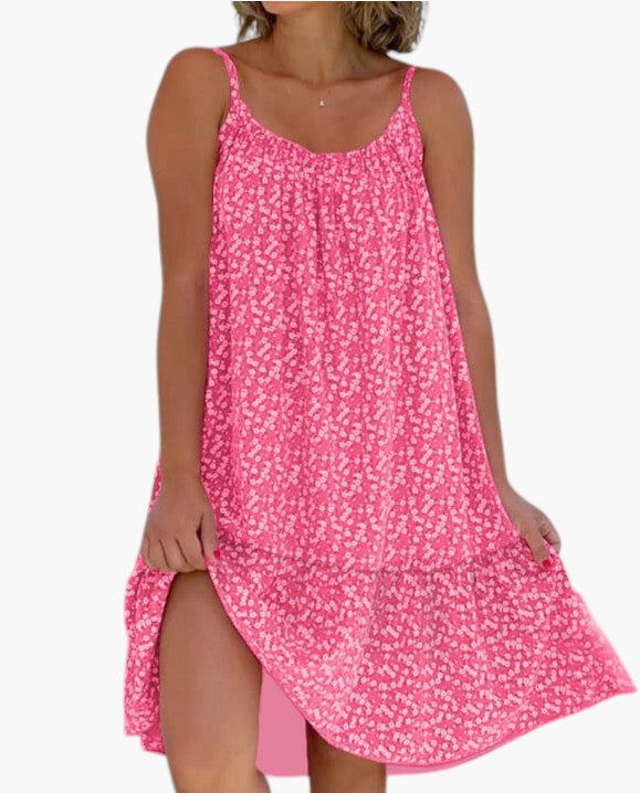 Robe légère rose à petites fleurs, bretelles fines, encolure arrondie, ourlet asymétrique.
