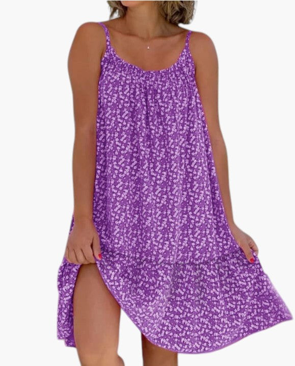 Robe légère violette à petites fleurs, bretelles fines, encolure arrondie, ourlet asymétrique.