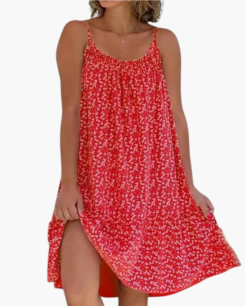 Robe légère rouge à petites fleurs, bretelles fines, encolure arrondie, ourlet asymétrique fendu.
