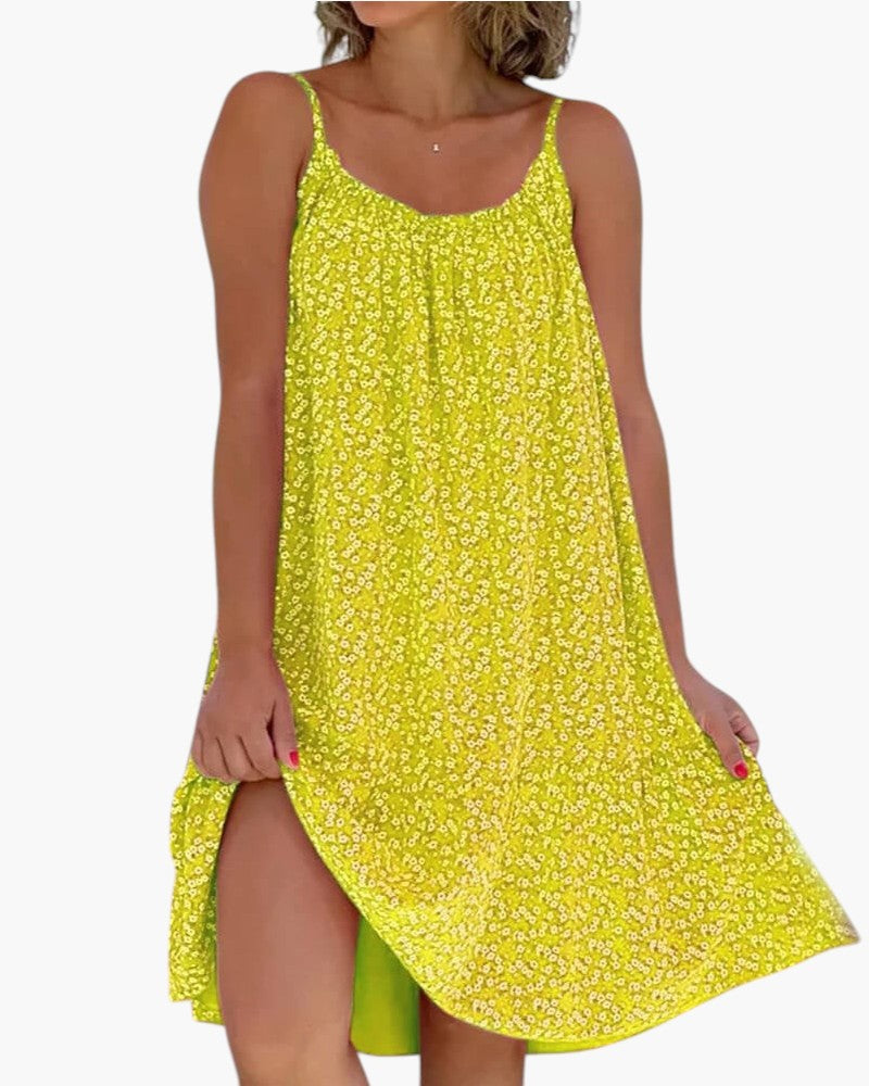 Robe légère jaune à petites fleurs, bretelles fines, encolure arrondie, ourlet asymétrique.