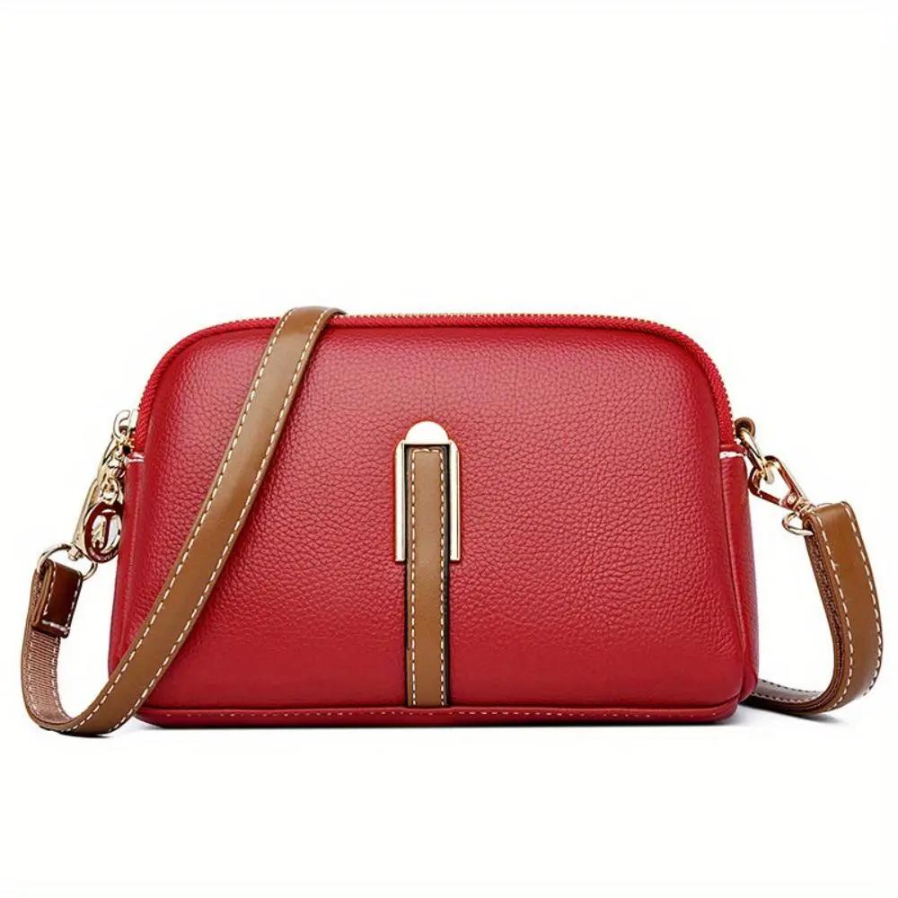 Sac bandoulière en cuir texturé rouge, bandoulière marron, fermeture zippée sur le dessus
