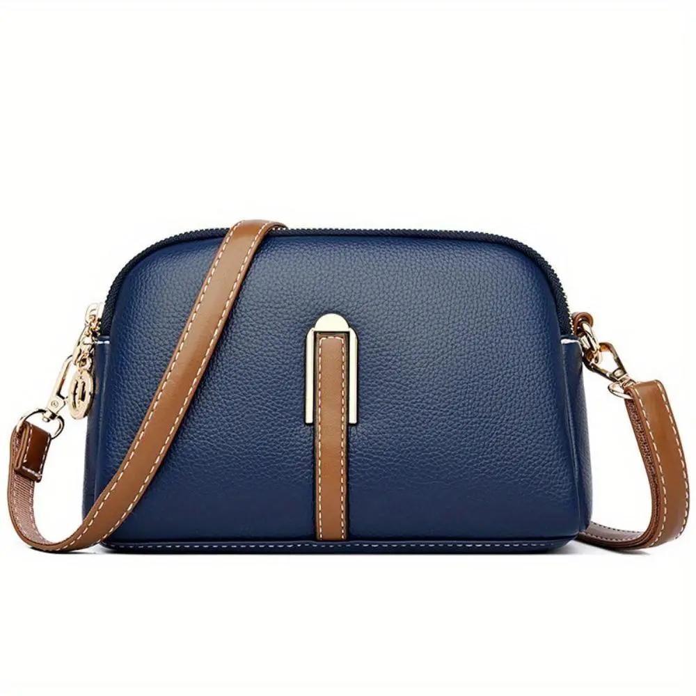 Sac bandoulière en cuir texturé bleu nuit, bandoulière marron, fermeture zippée centrale