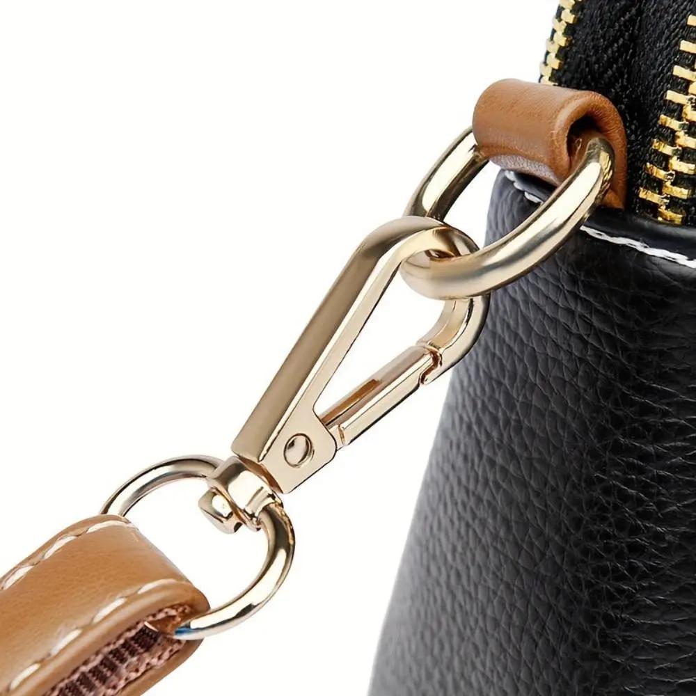 Fermoir et anneaux du sac bandoulière Sienne en métal doré, lanière marron