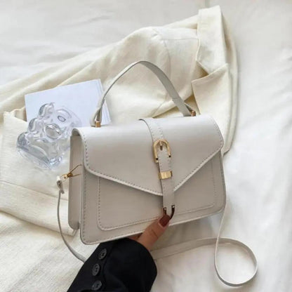 Sac à bandoulière blanc cassé avec rabat et fermoir doré, anse courte et bandoulière.