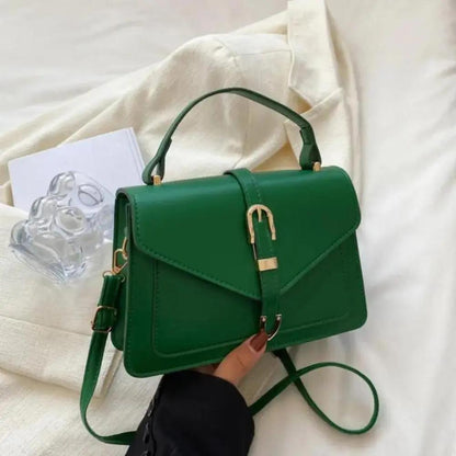 Sac à bandoulière vert avec rabat et fermoir doré, poignée courte et sangle amovible.