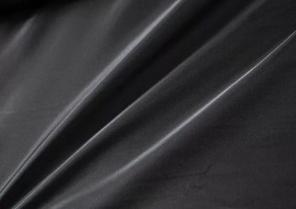 Doublure intérieure noire satinée du manteau, tissu lisse visible