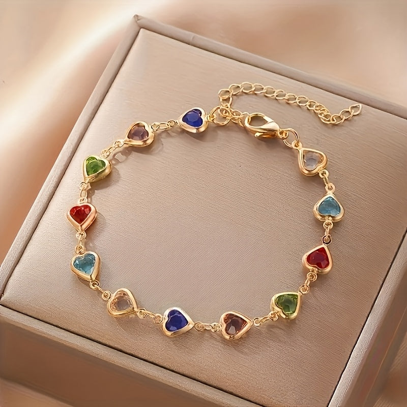 Bracelet doré à breloques en cœurs colorés : rouge, bleu, vert et rose.