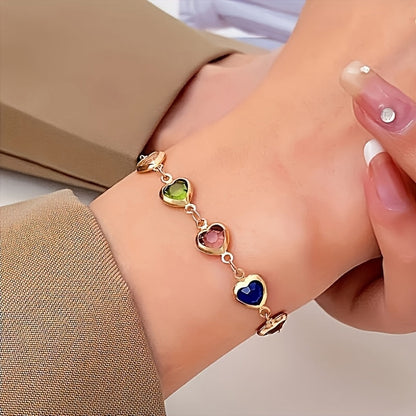 Bracelet fin doré avec cœurs émaillés colorés porté au poignet.