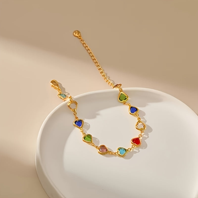 Bracelet doré en forme de cœurs émaillés, présenté sur un support blanc.