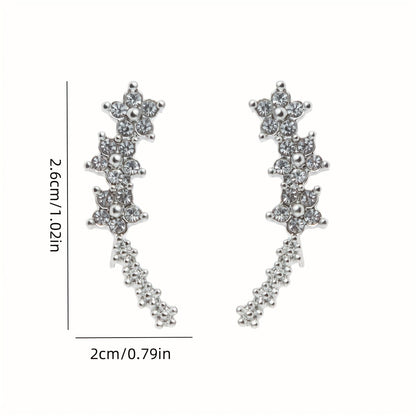 Boucles d’oreilles fleurs en strass blanc, dimensions visibles, longue forme en V.